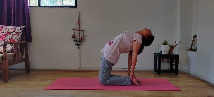 A student practising Ustrasana, the camel pose
